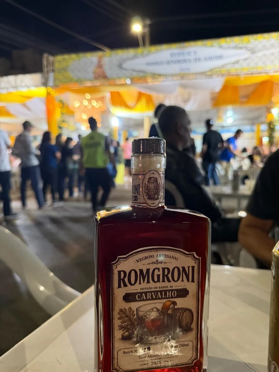 Garrafa de Romgroni Carvalho sobre a mesa, numa festa à noite